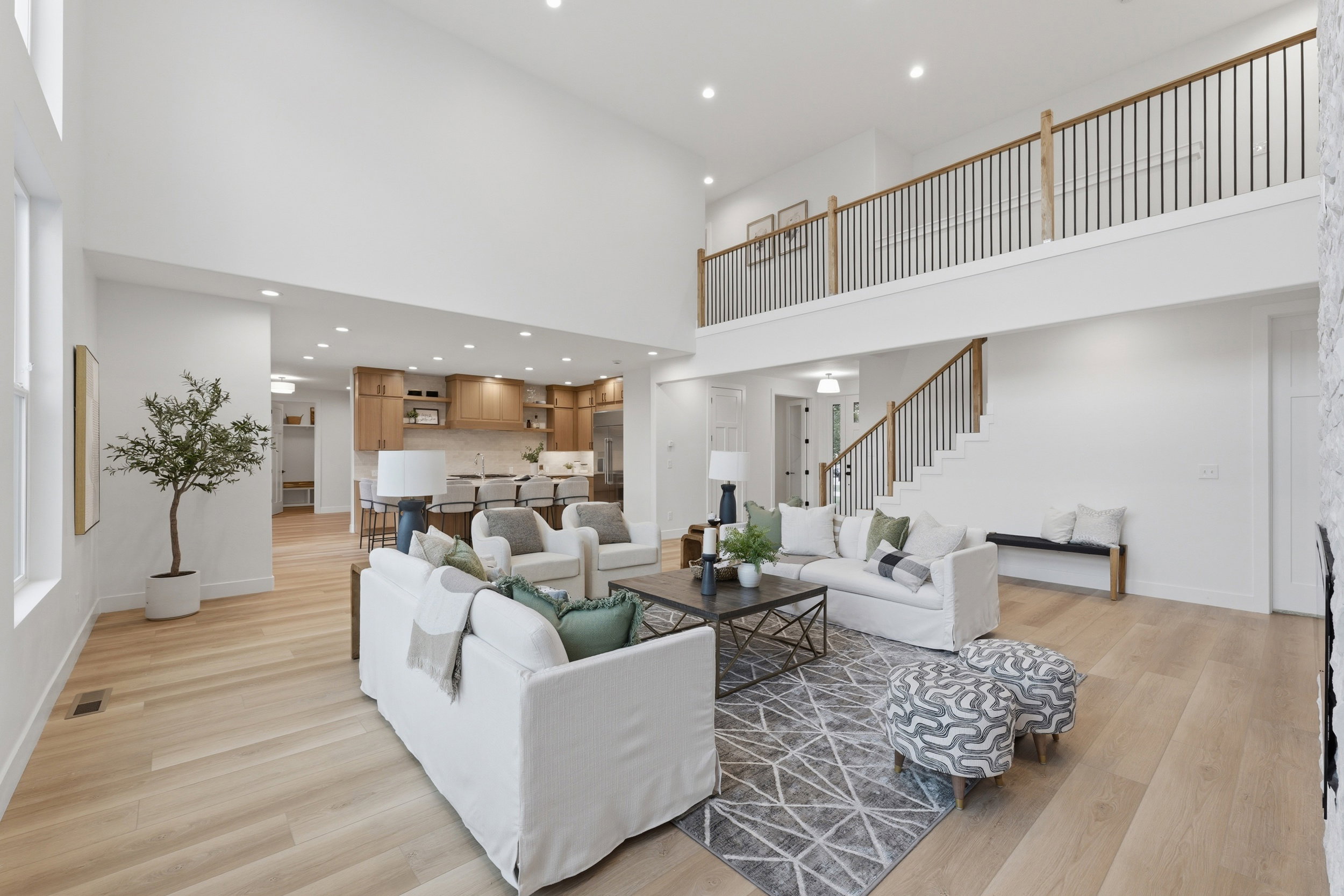 Two-story living area featuring wood-finish flooring, a vaulted ceiling, and an open loft