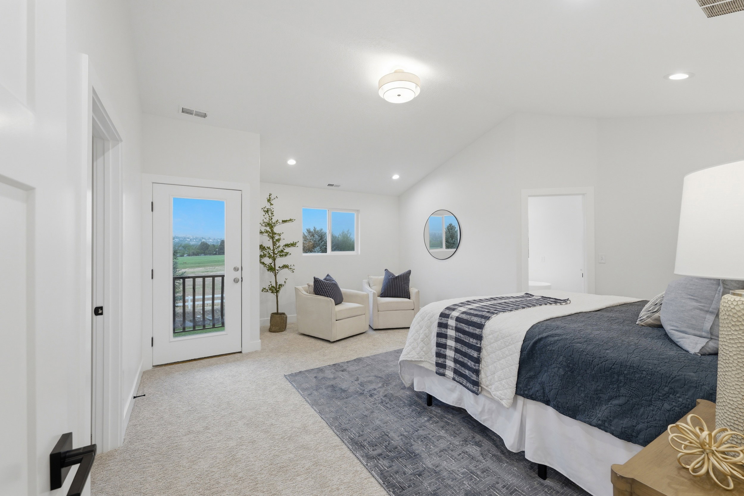 Spacious bedroom featuring light-toned carpeting, a vaulted ceiling, and recessed lighting