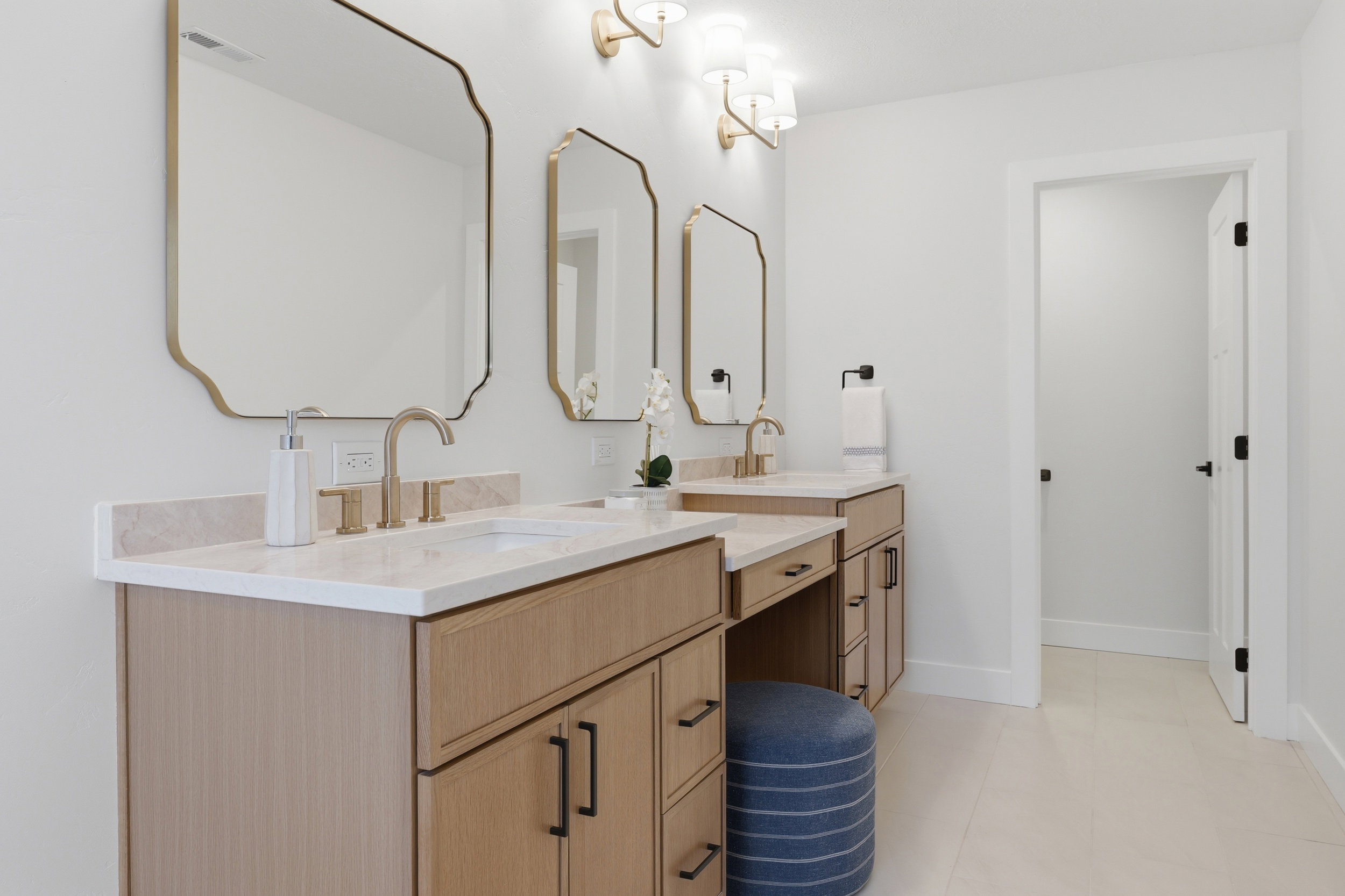 Double vanity with light wood-finish cabinetry and white countertops