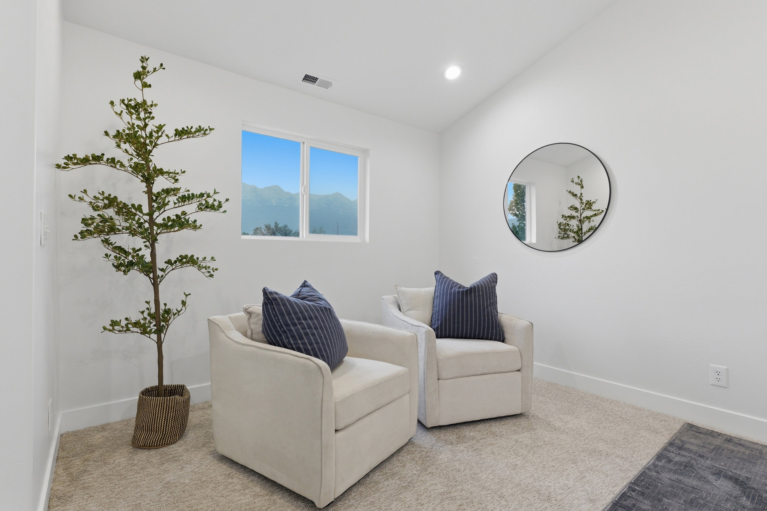 Bright room featuring a window with a mountain backdrop, recessed ceiling lighting, and carpet flooring