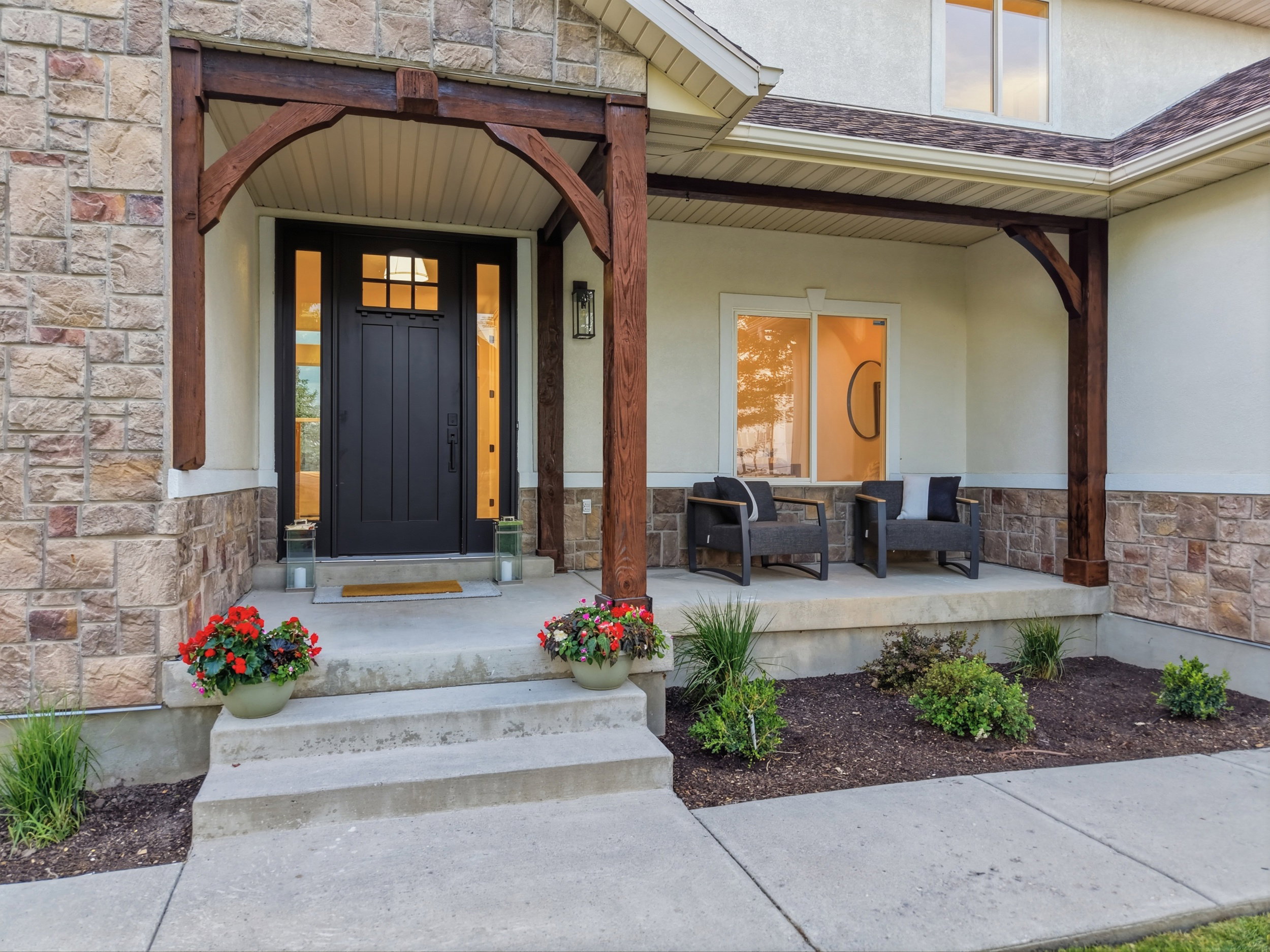 Stone and stucco exterior featuring a dark wood-paneled entry door with sidelights and transom window