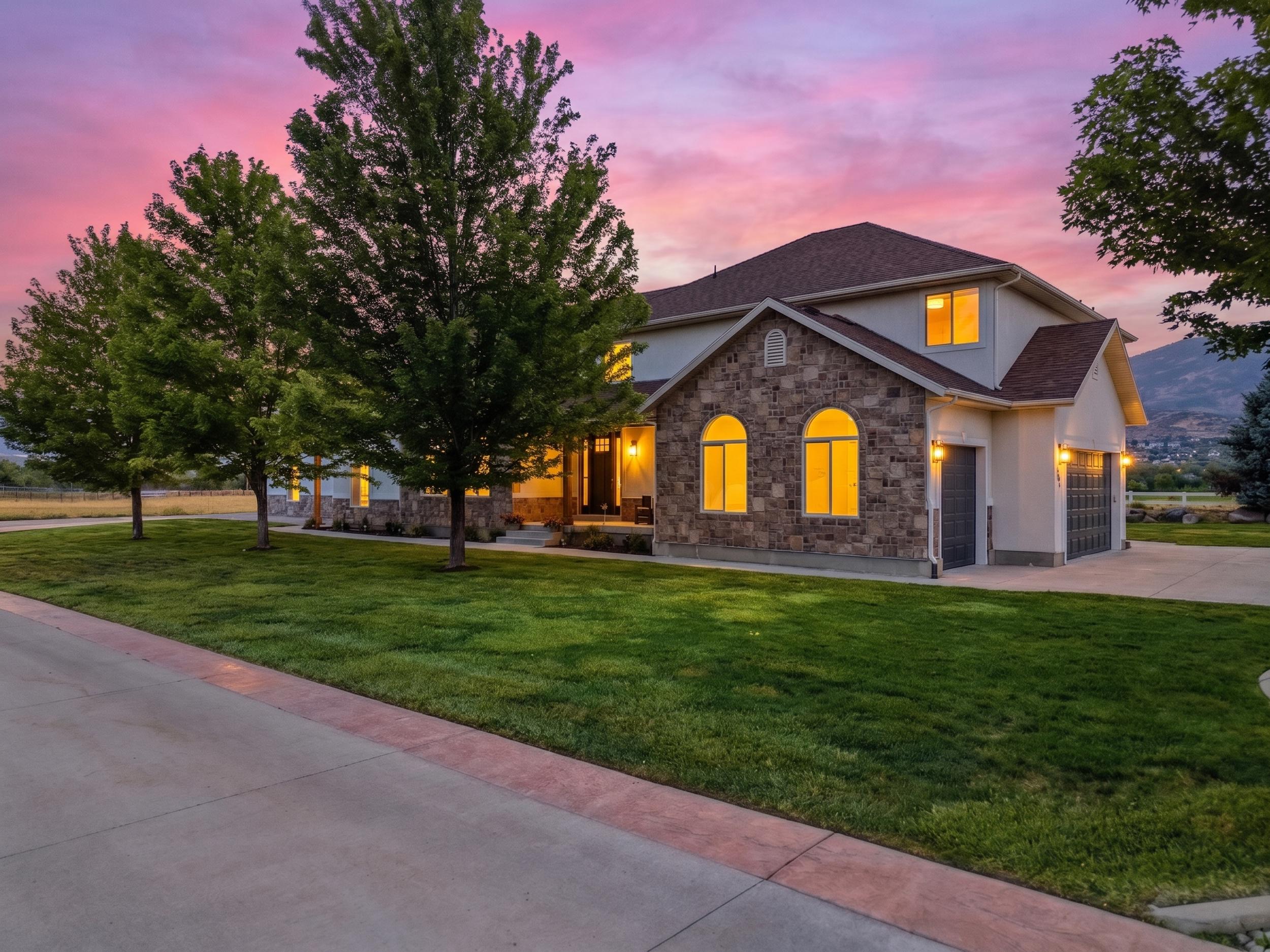 Stately exterior featuring stone accents, arched windows, and a multi-car garage