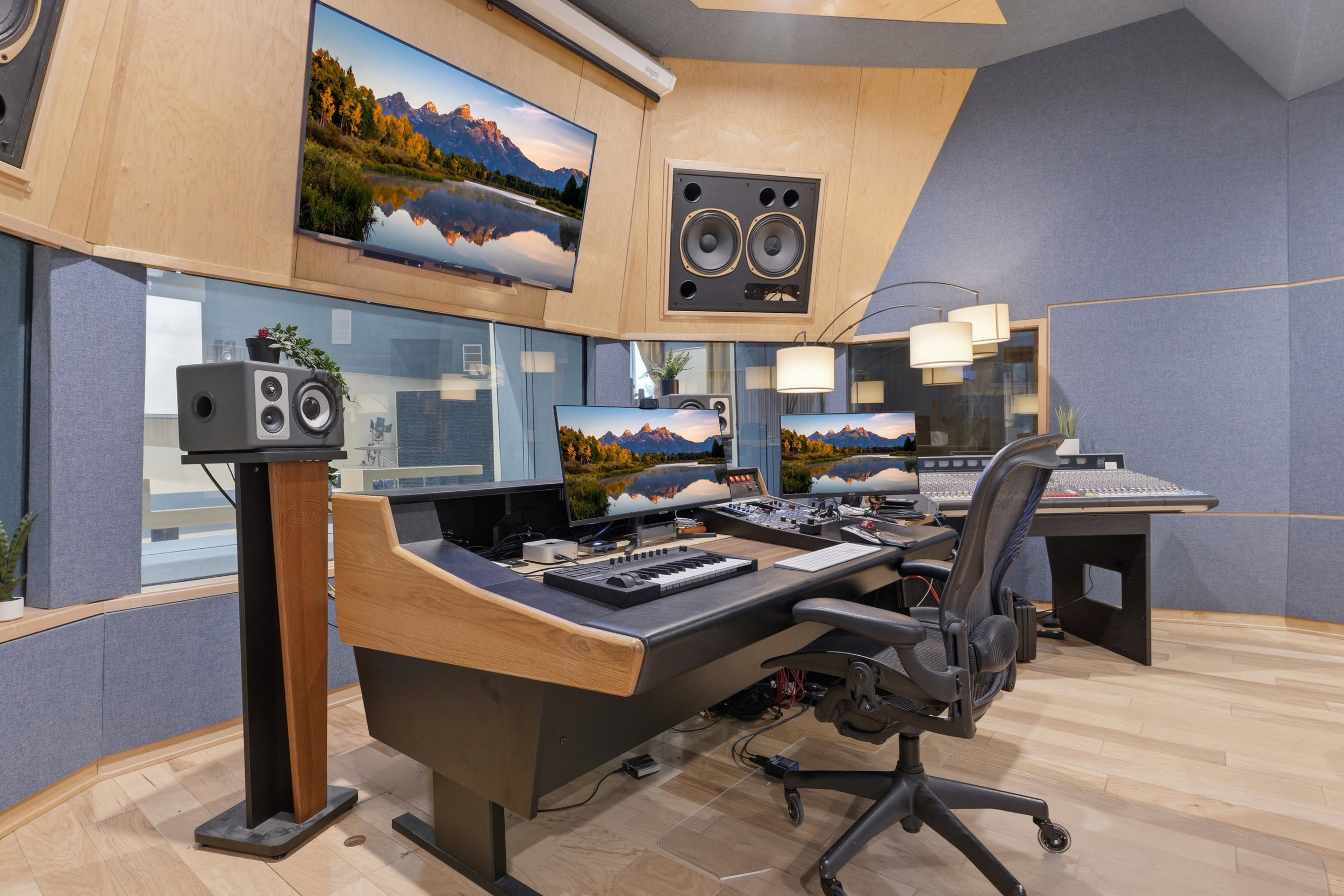 Professional studio space featuring light wood-finish flooring, acoustic paneling, and an integrated soundboard