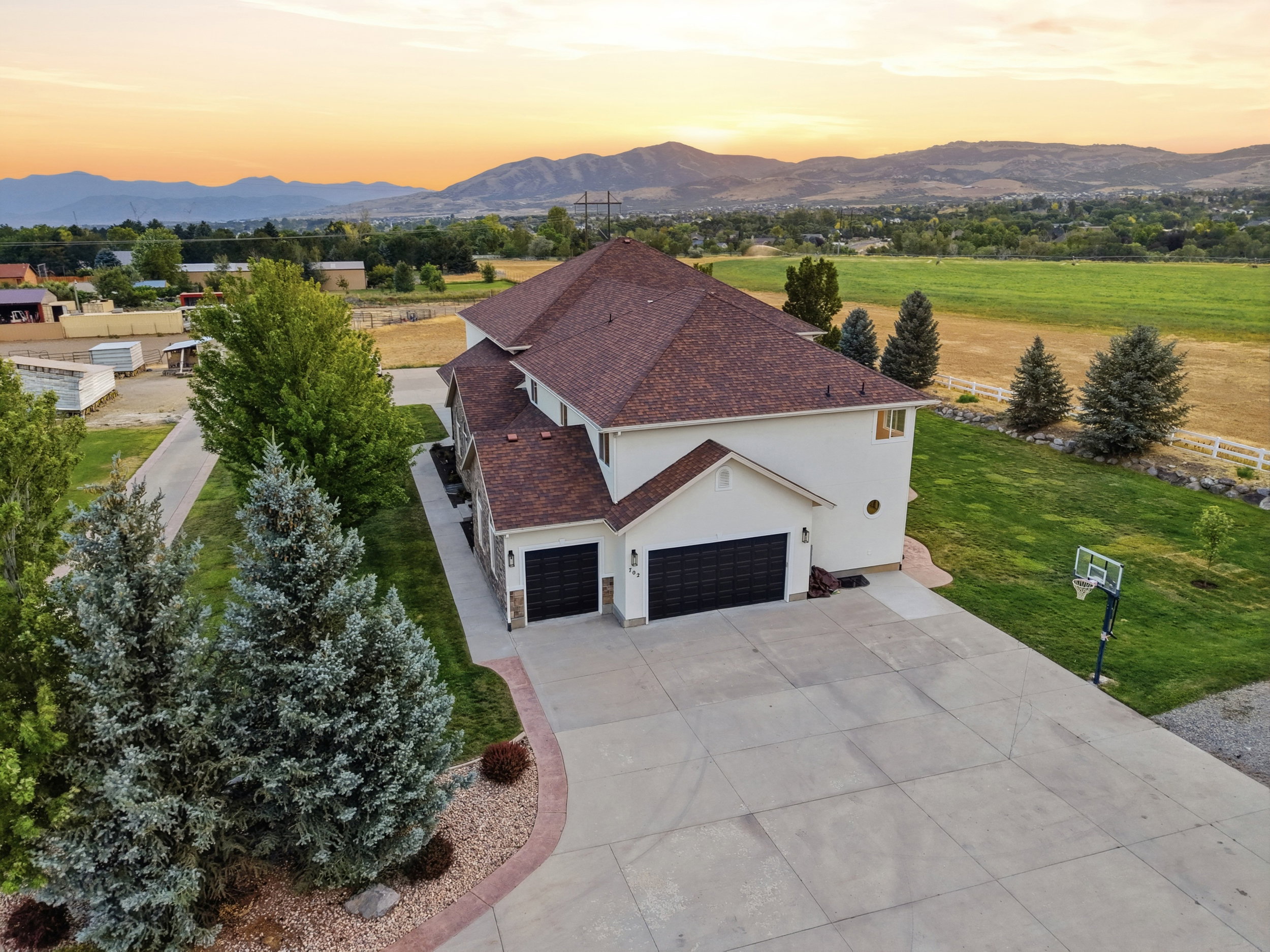 Spacious property featuring a large concrete driveway, two-car garage, and stone accents