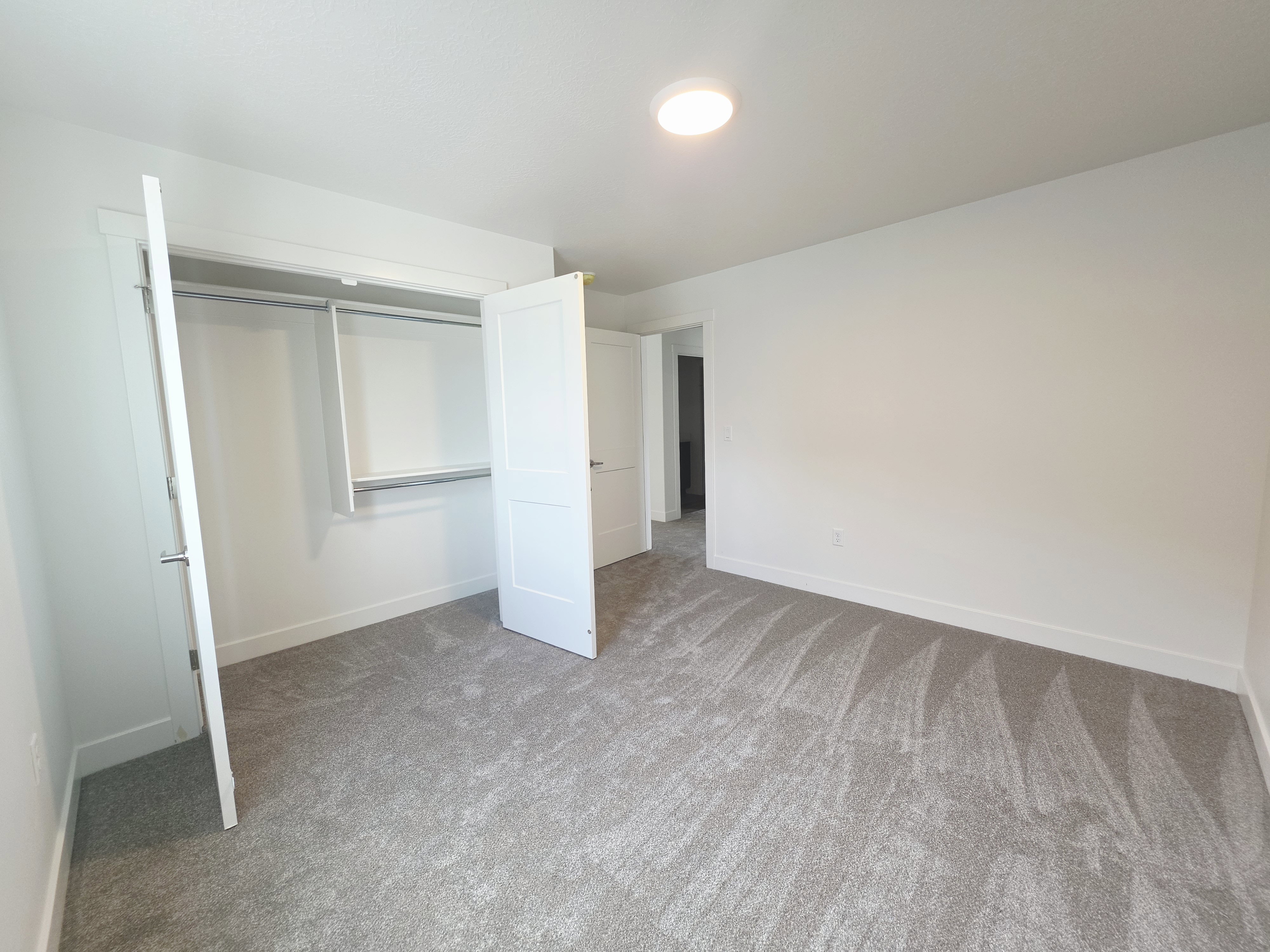 Bright interior space featuring a built-in closet with shelving and hanging rods