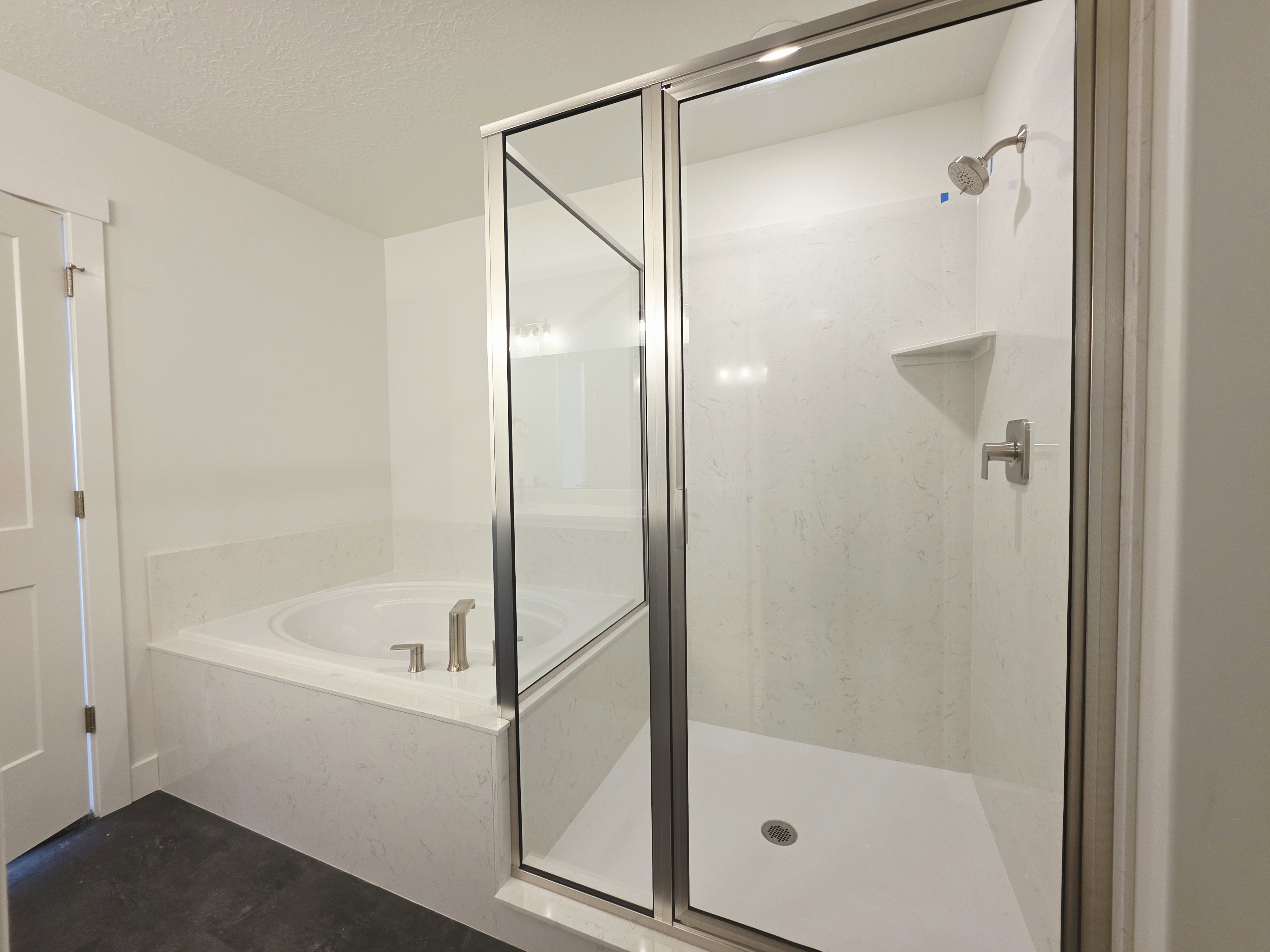 Contemporary bathroom featuring a glass-enclosed shower with a built-in shelf and a separate soaking tub with brushed nickel fixtures