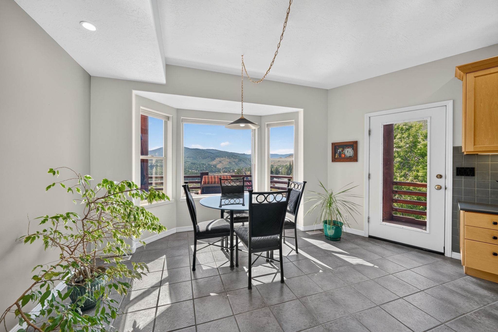 Bay window seating area featuring a mountain backdrop, a glass-paneled door, recessed lighting, and tile flooring