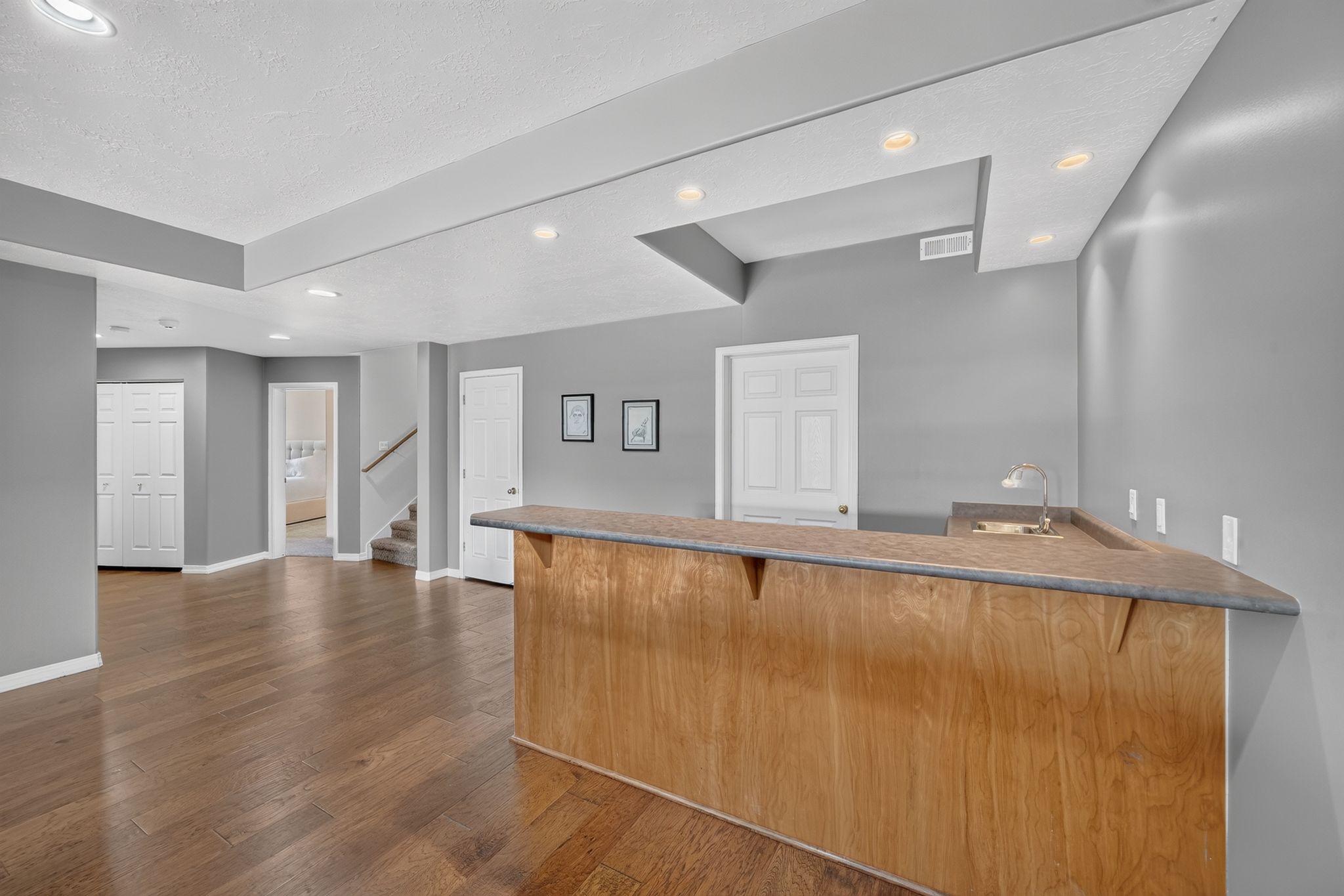 Spacious finished basement featuring wood-finish flooring and recessed lighting