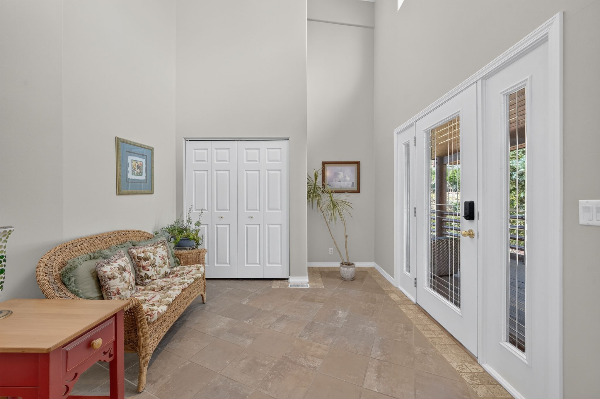 Entryway featuring double French doors with sidelights, vaulted ceilings, tiled flooring, and bifold closet doors