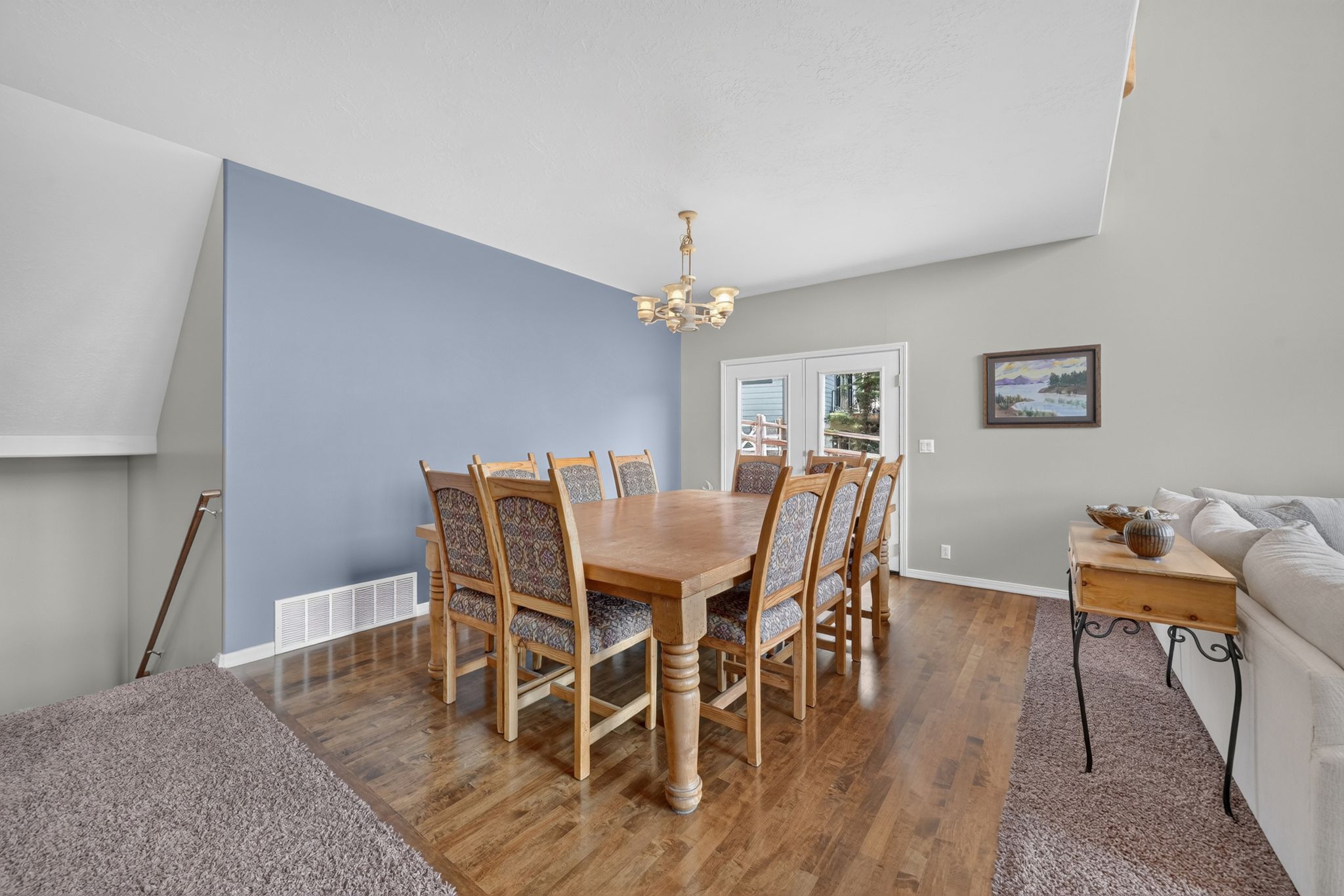 Dining area featuring wood-finish flooring and a central chandelier