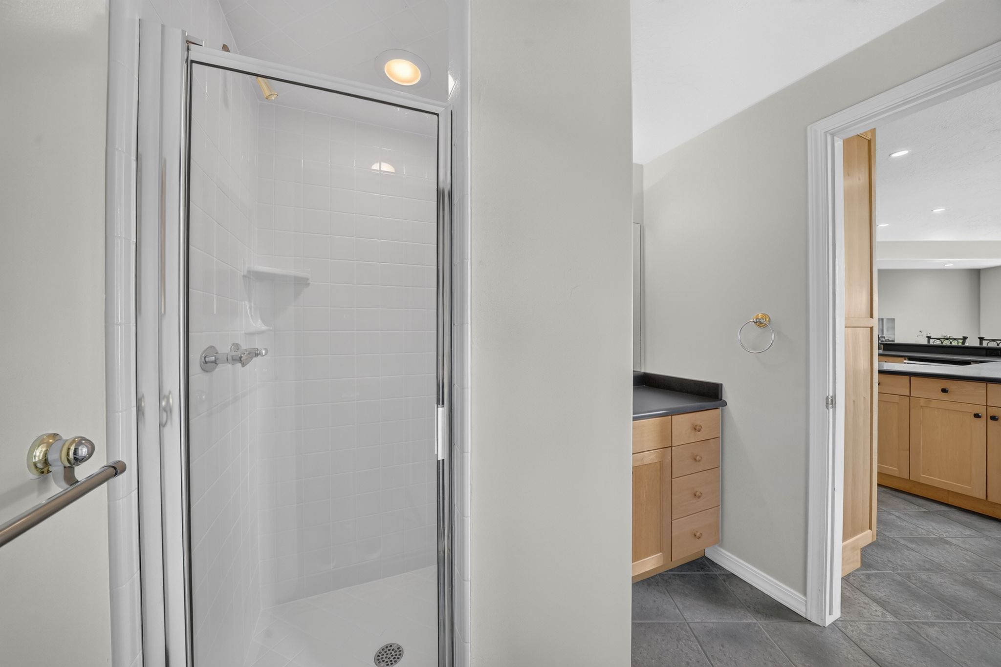Glass-enclosed shower featuring white subway tile, a recessed light, and chrome fixtures
