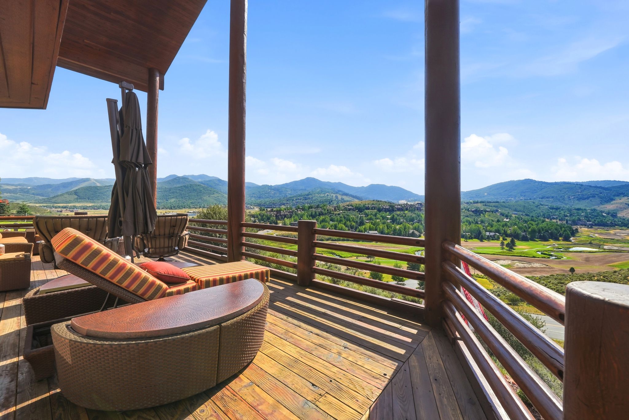 Expansive outdoor deck featuring wood-finish flooring and a wood railing