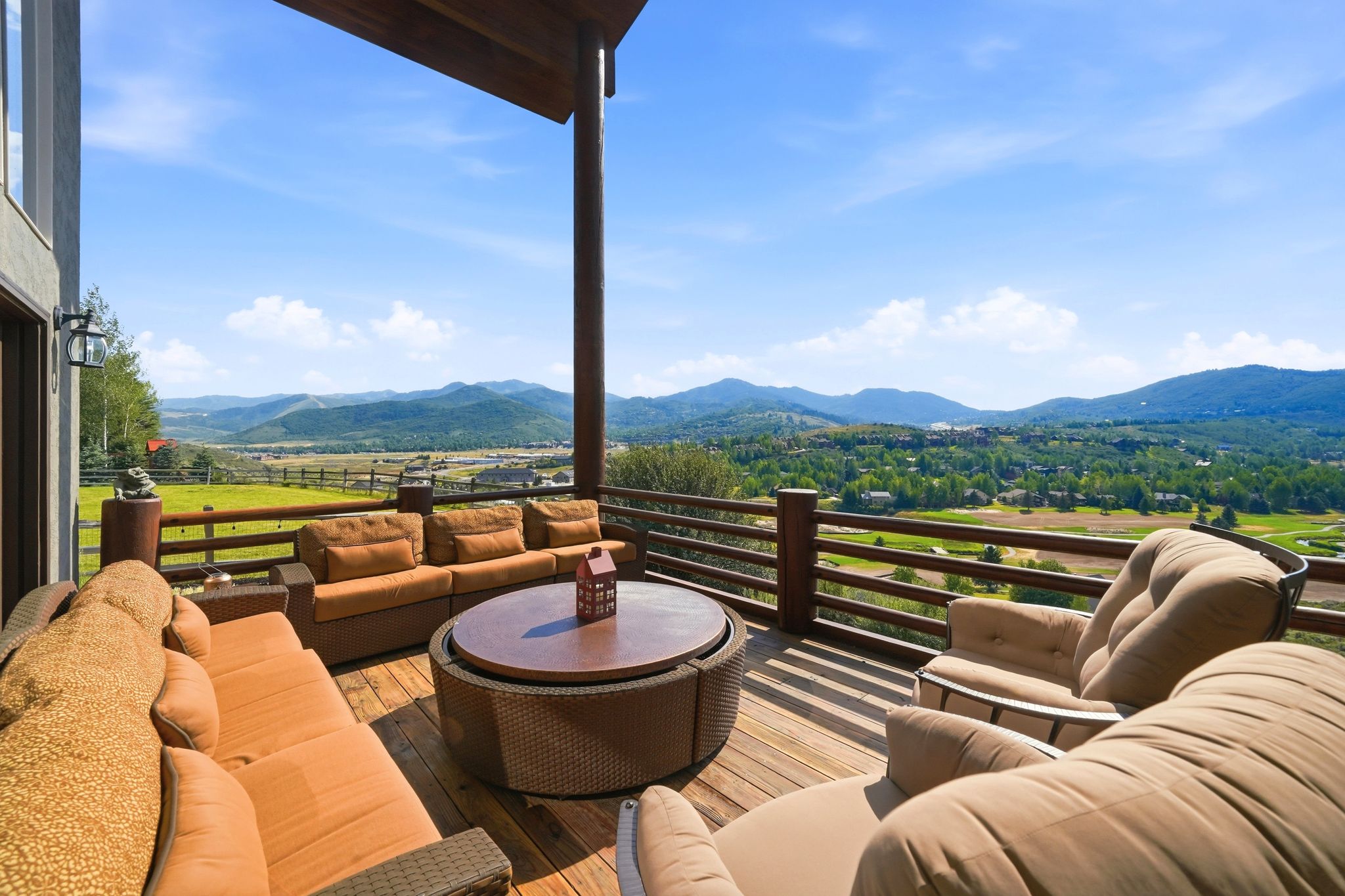 Elevated outdoor deck with wood-finish flooring, robust timber railings, and a substantial overhead beam structure