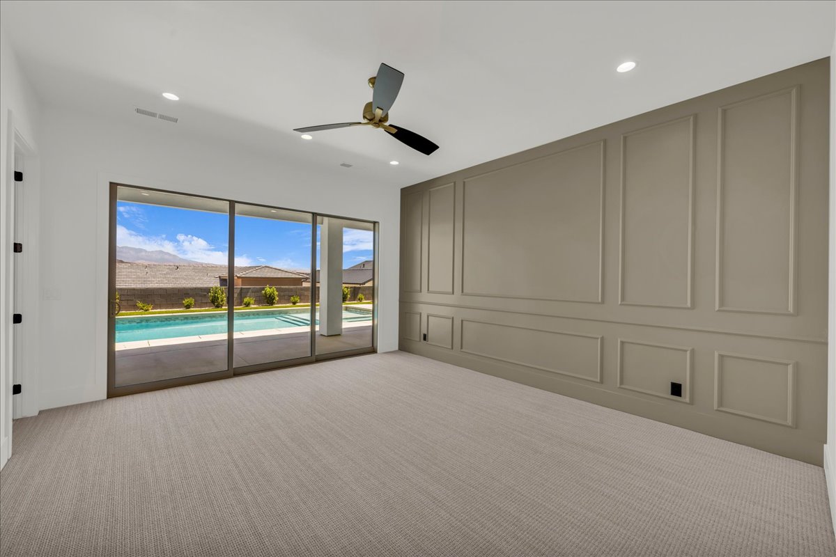 Spacious room featuring broadloom carpeting, a full wall of decorative panel molding, and recessed lighting