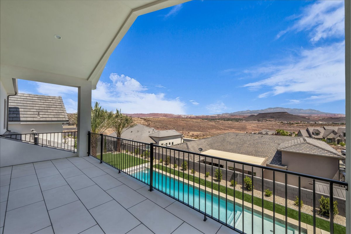 Spacious covered balcony featuring large format tile flooring and black metal railings