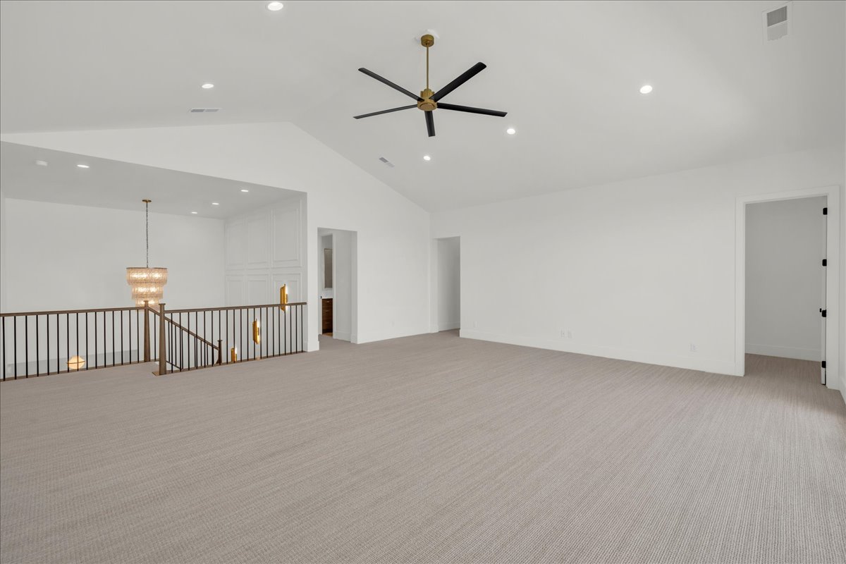 Spacious loft area featuring vaulted ceilings, recessed lighting, and neutral-tone carpeting