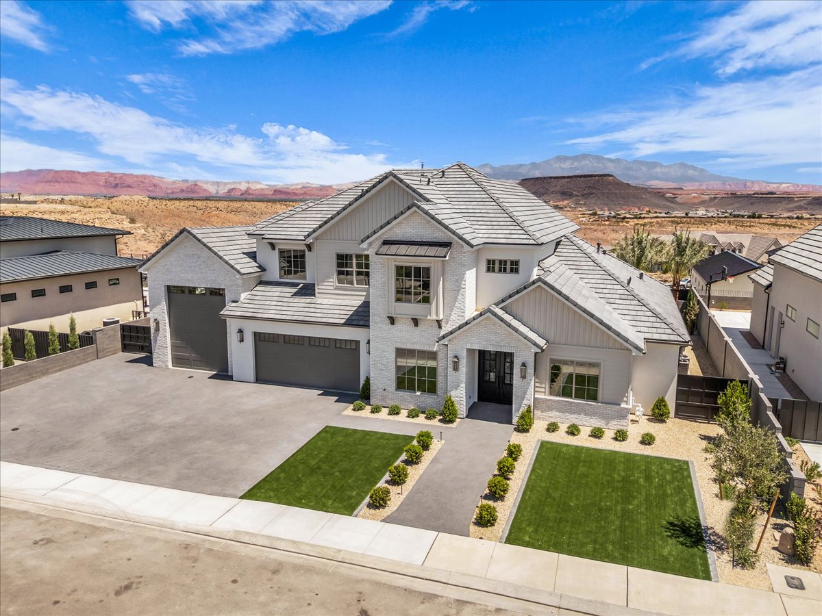 Contemporary residence featuring a white brick exterior and a gray tile roof
