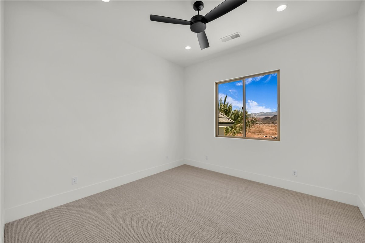 Spacious room featuring a large window, recessed lighting, and a modern ceiling fan