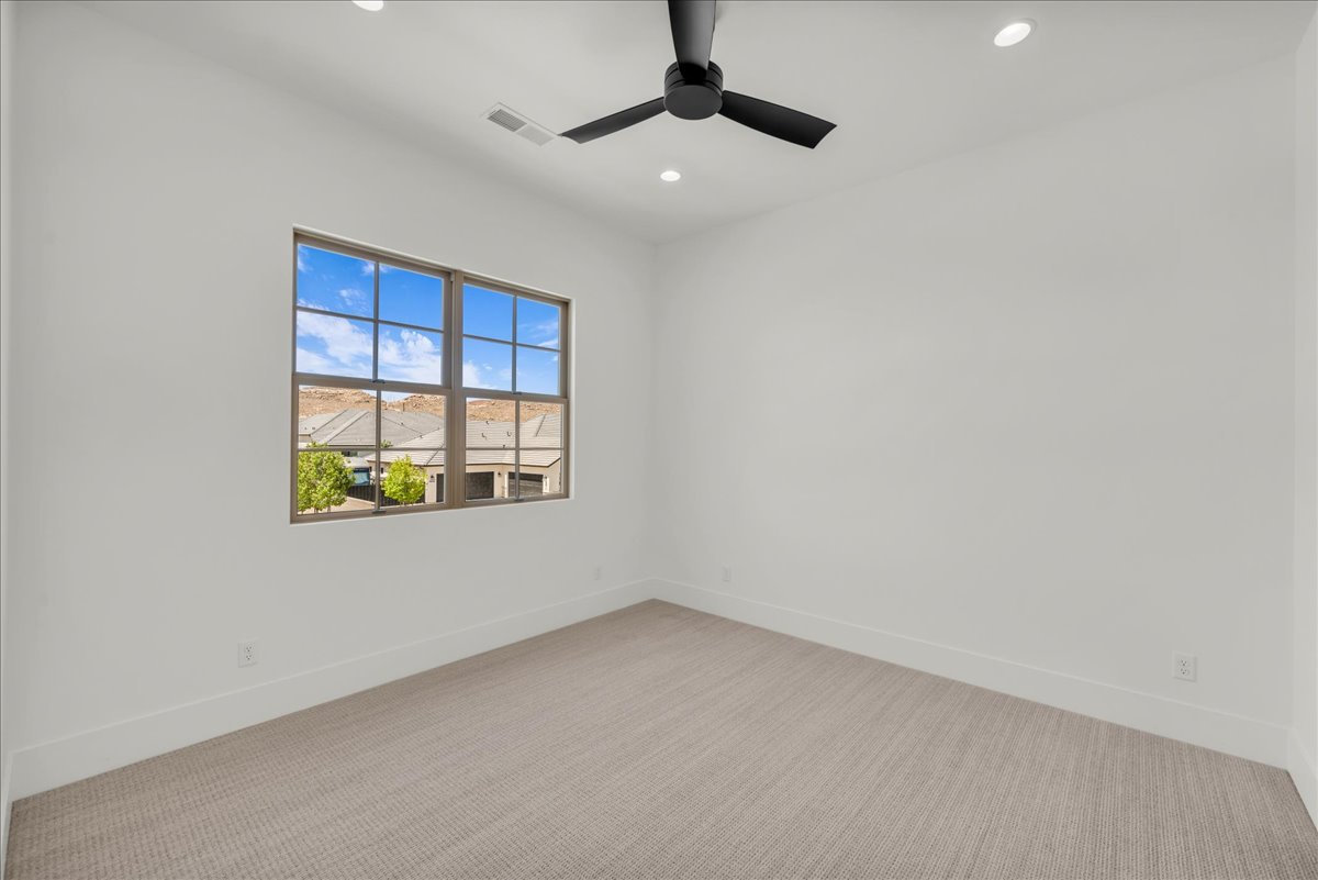 Interior room featuring a large gridded window, recessed lighting, and a modern ceiling fan