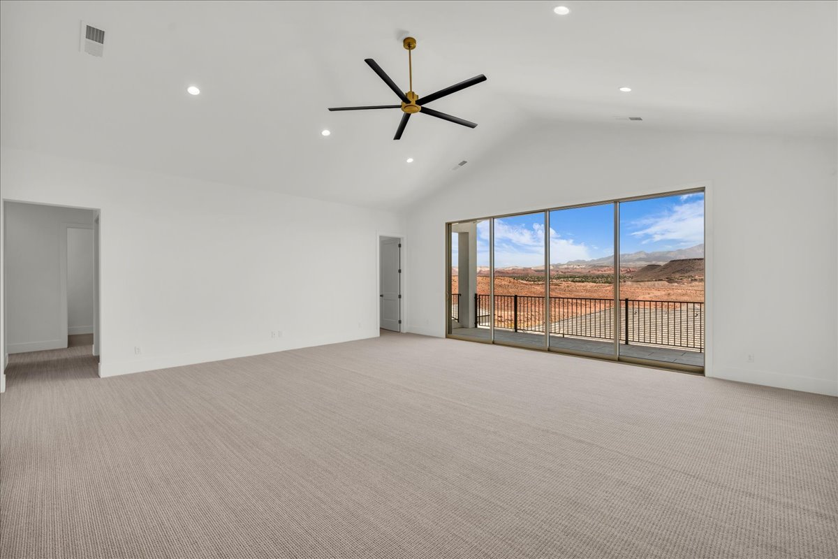 Spacious interior room featuring a vaulted ceiling and recessed lighting