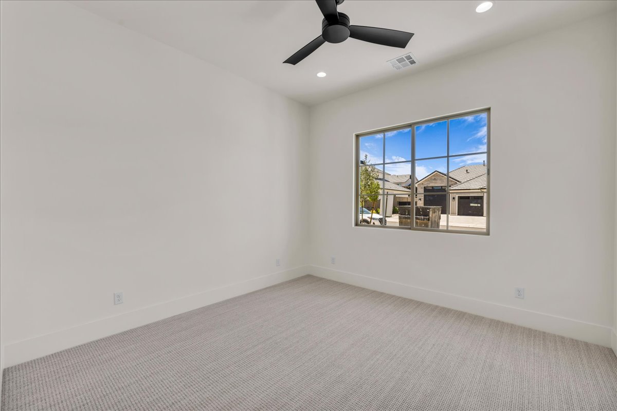 Spacious interior room featuring a large multi-pane window, recessed lighting, and a contemporary ceiling fan