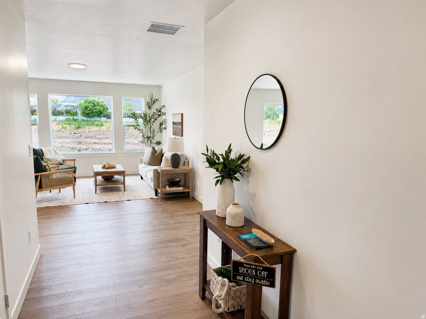 Bright living space featuring multiple large windows, wood-finish flooring, recessed lighting, and a white ceiling