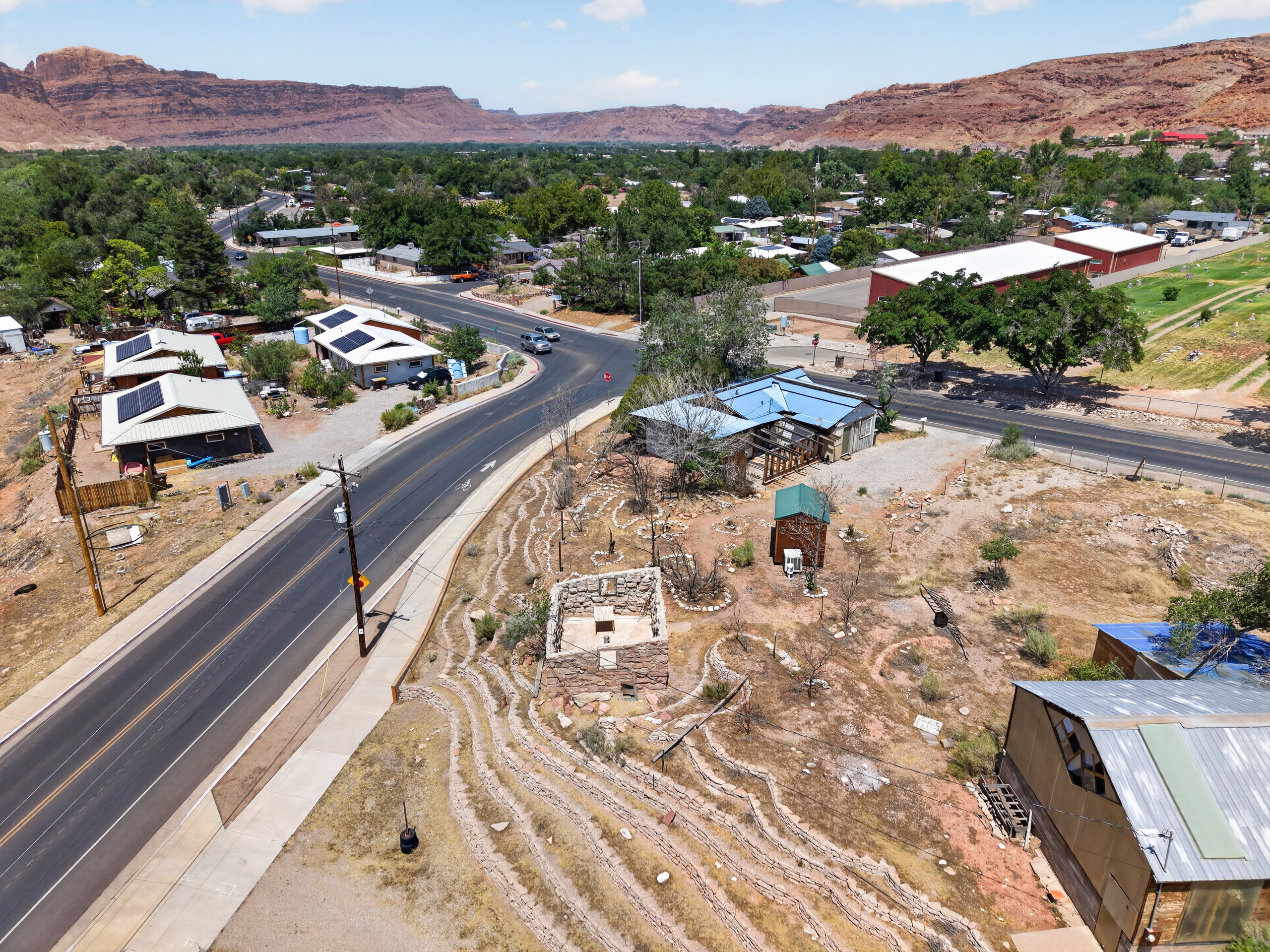 Expansive desert landscape featuring a winding road and distant red rock formations