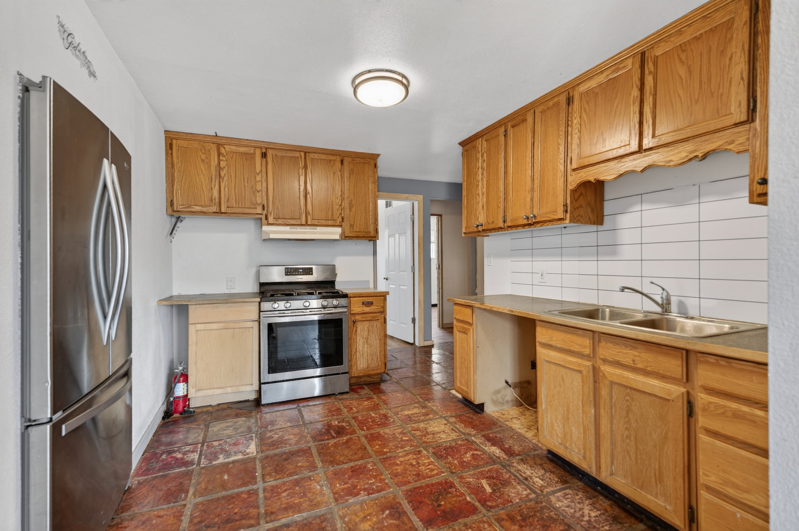 Kitchen featuring wood cabinetry, stainless steel appliances, and a double basin sink