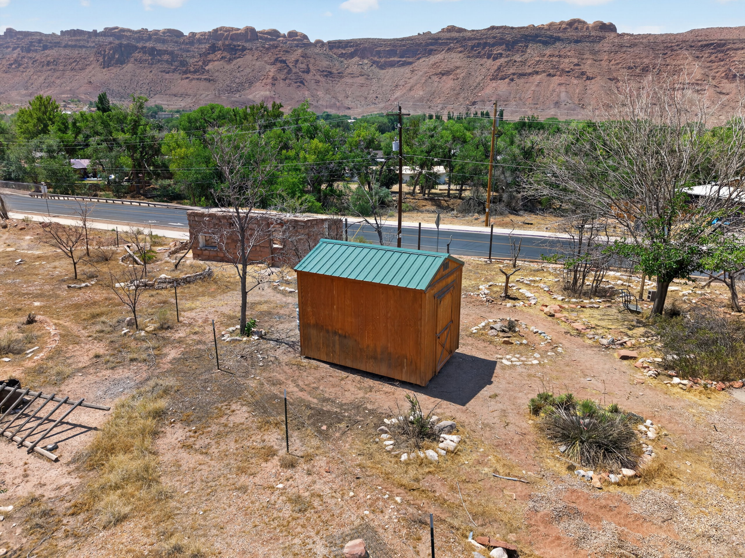Wood-sided shed featuring a green metal roof