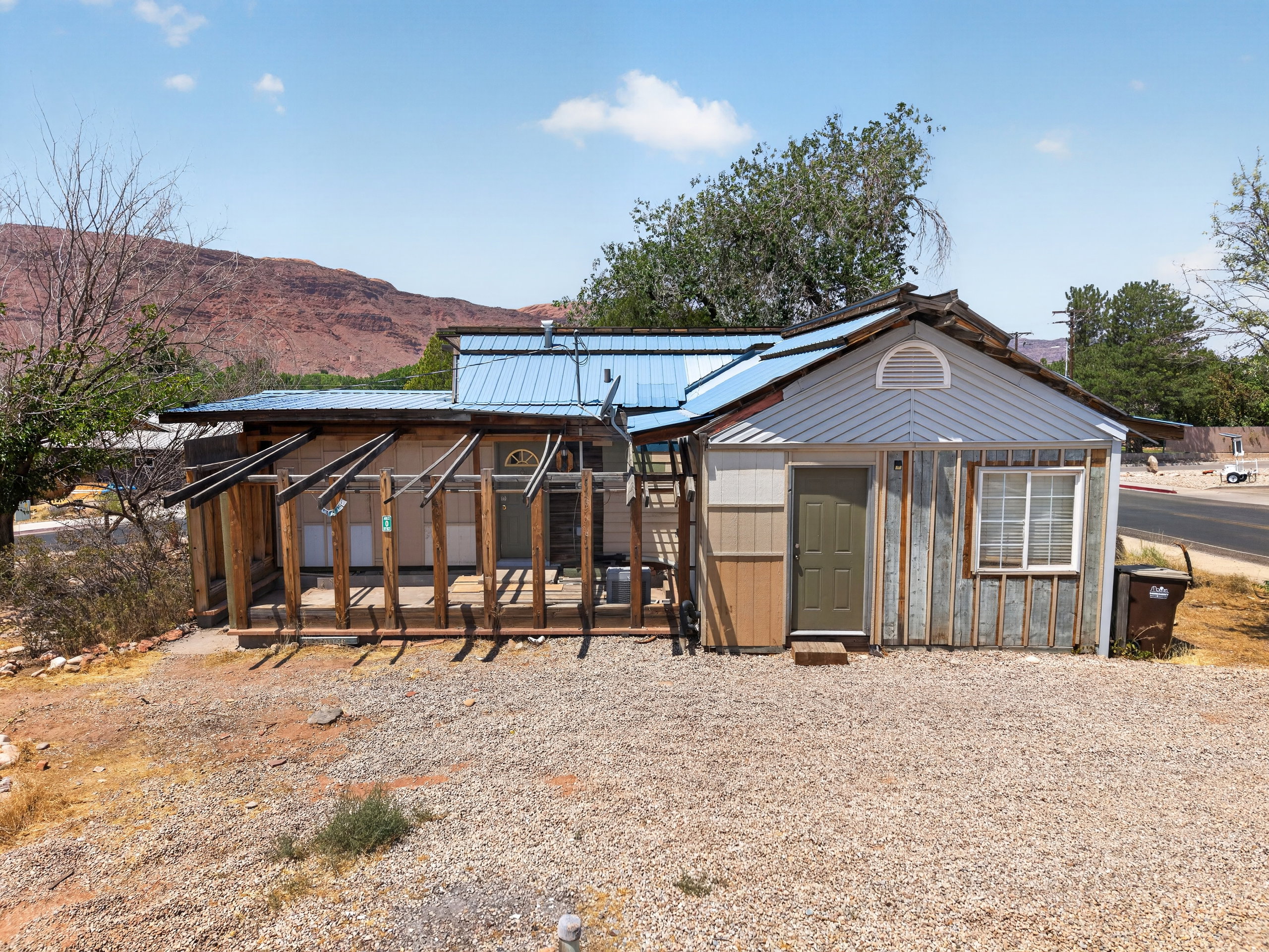 Property exterior featuring multiple siding types and a blue metal roof