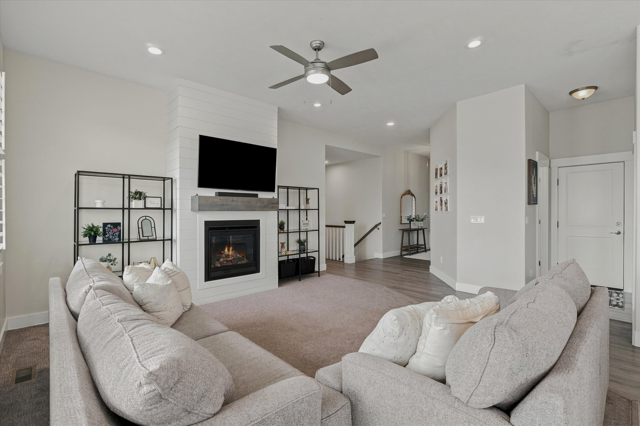 Living area featuring a floor-to-ceiling fireplace with shiplap detailing and a wood-finish mantel