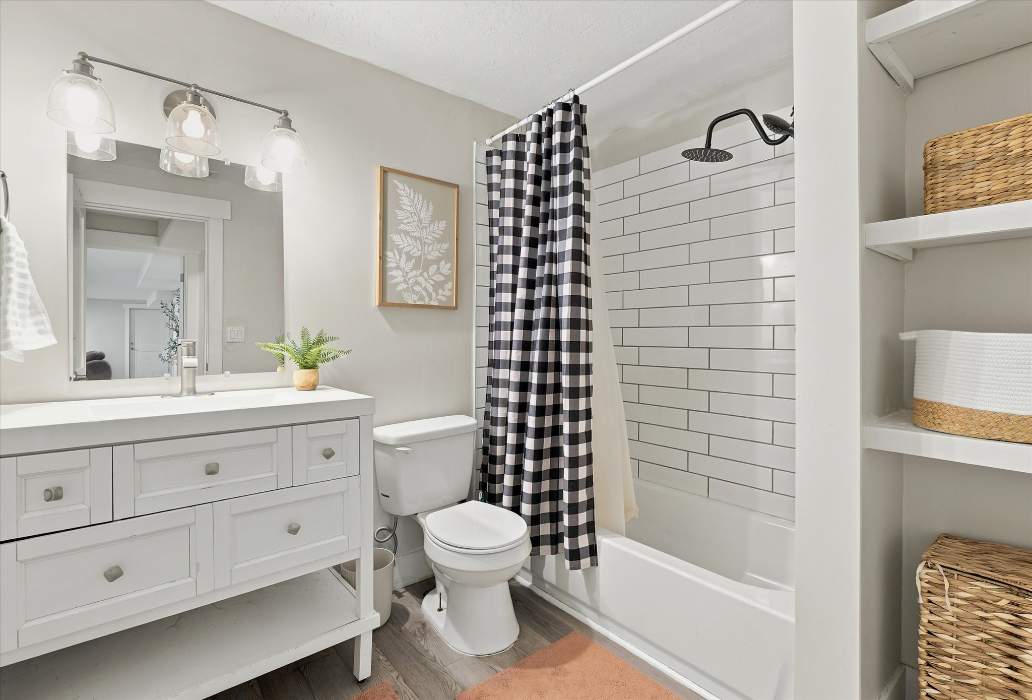 Bathroom featuring a white vanity with brushed nickel hardware, an integrated sink, and a framed mirror