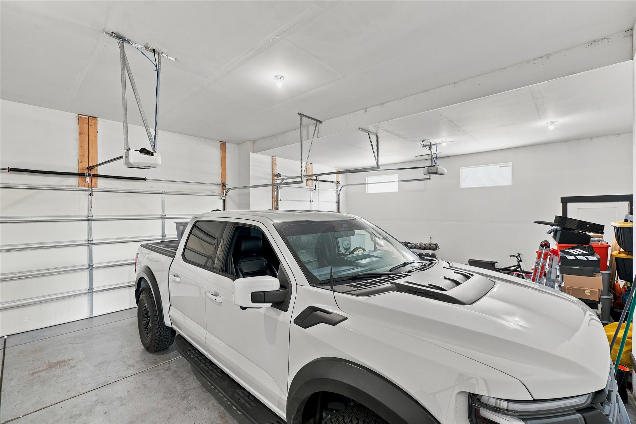 Spacious garage featuring a concrete floor, multiple automatic garage door openers, and recessed lighting