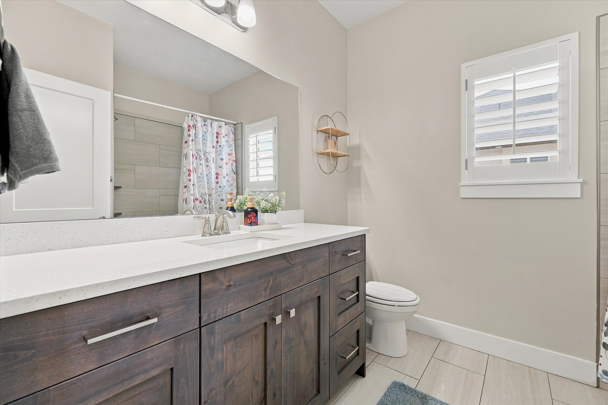 Contemporary bathroom featuring a dark wood-finish vanity with a white countertop and undermount sink