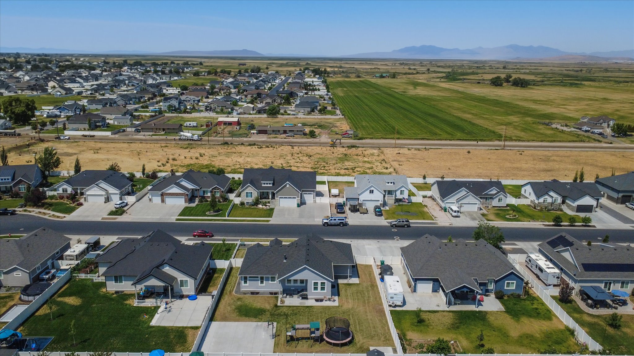 New construction residential area featuring single-story homes with dark shingle roofs