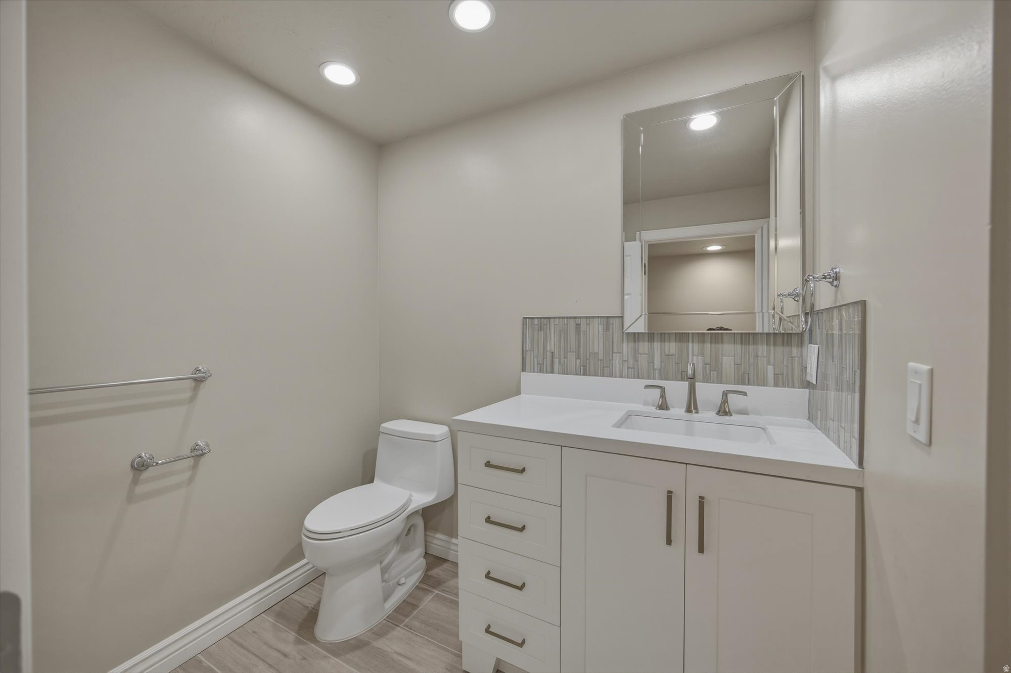 Contemporary vanity featuring a white countertop, undermount sink, and brushed nickel faucet