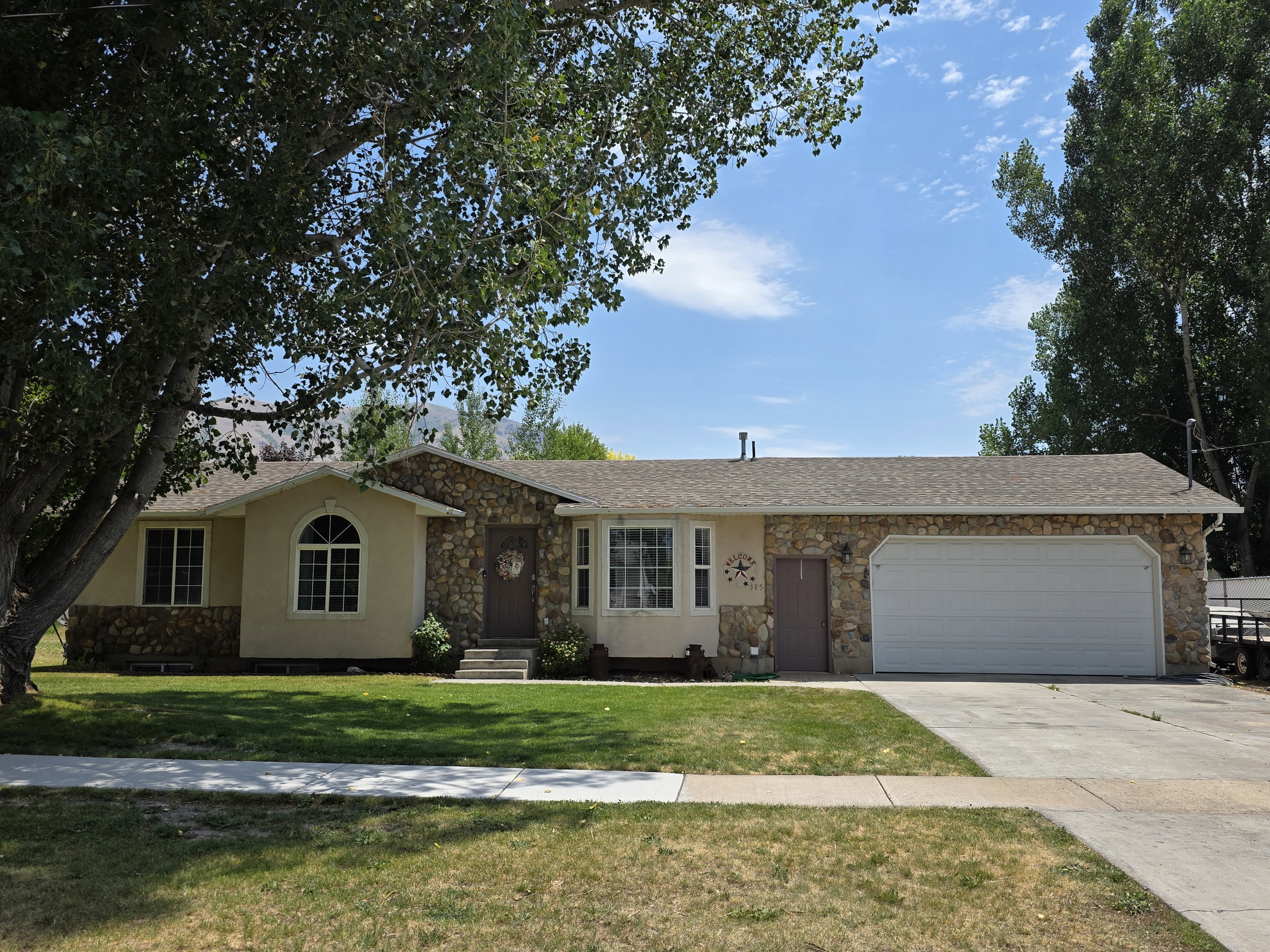 Ranch-style exterior featuring stone veneer and stucco siding