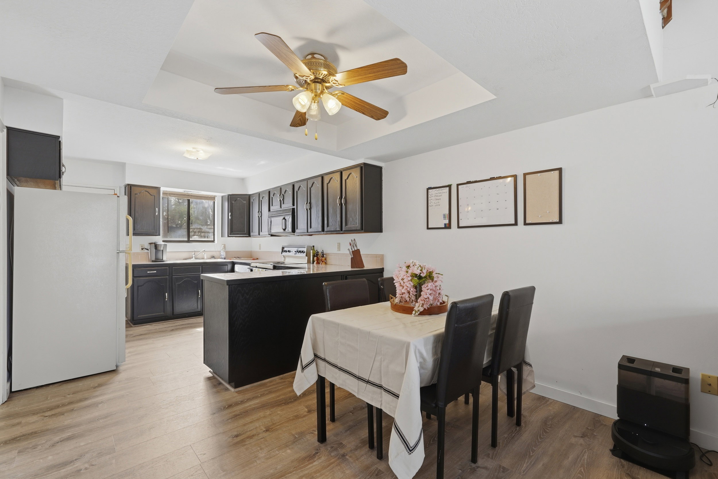 Open concept kitchen with dark cabinetry, light countertops, and LVP flooring