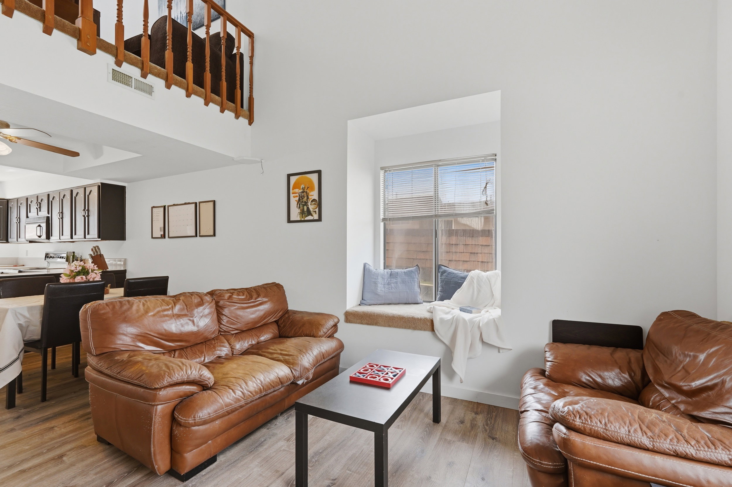 Open-concept living area featuring high ceilings, LVP flooring, and a built-in window seat