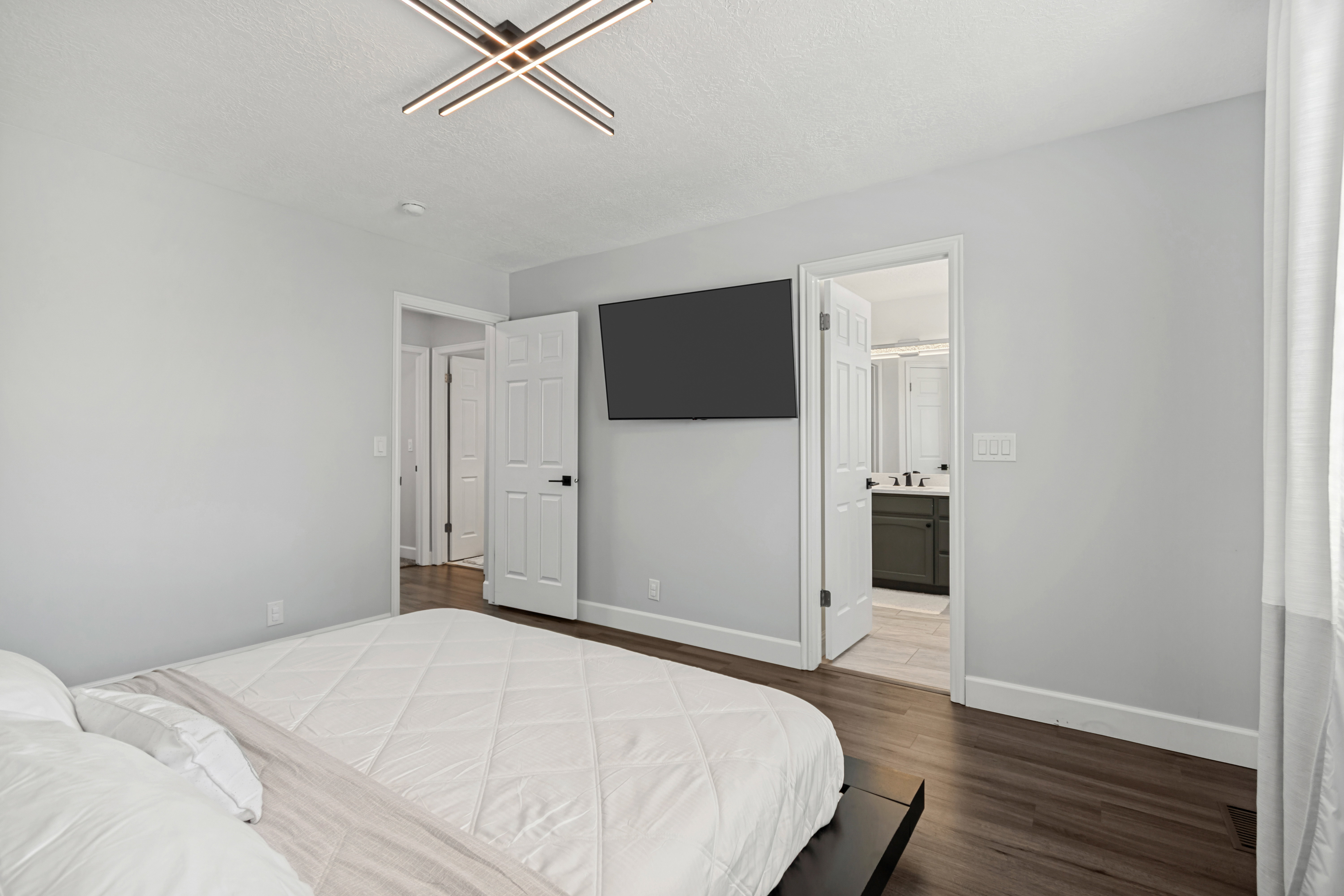 Room featuring wood-finish flooring, light gray walls, and a contemporary ceiling light fixture