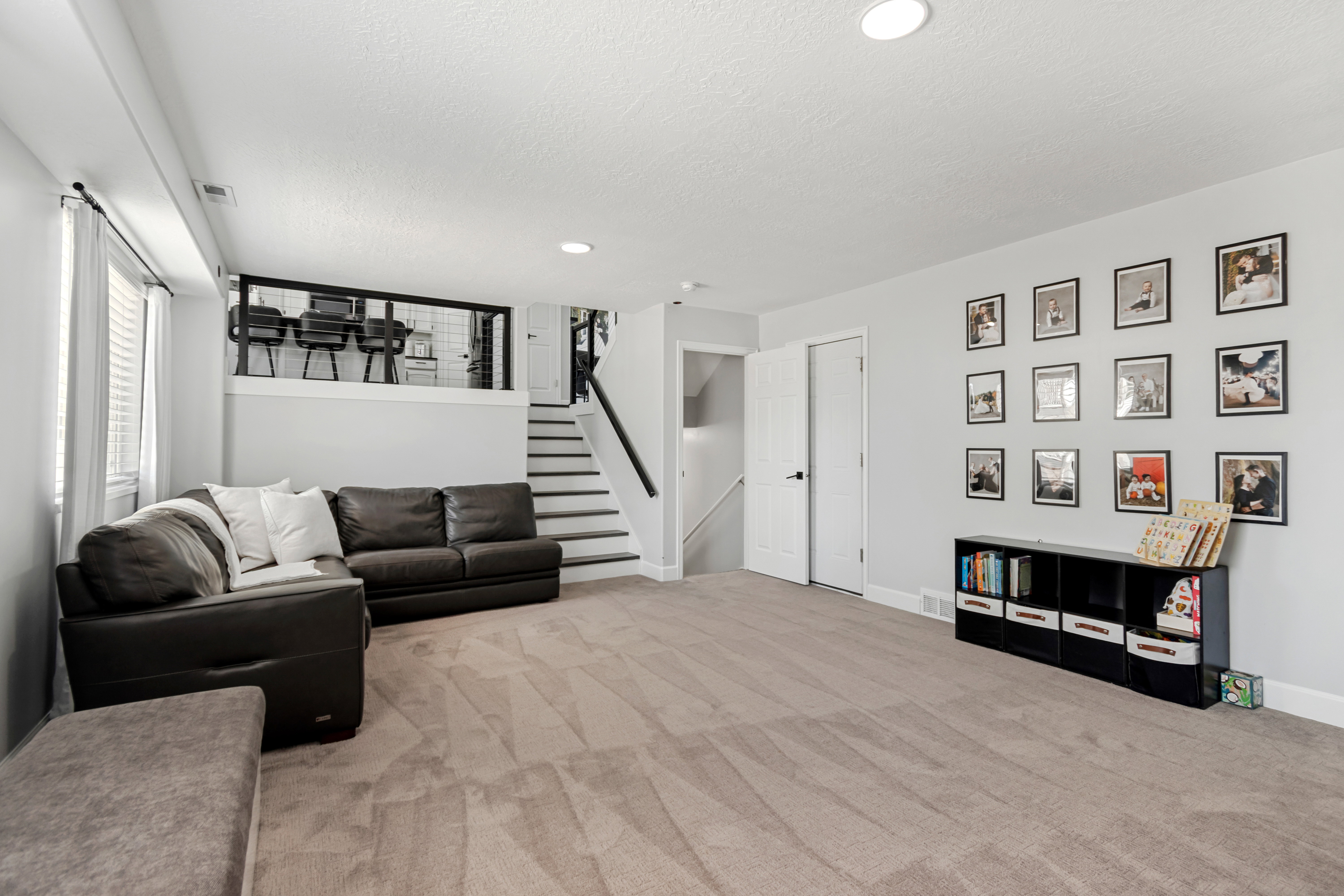 Spacious finished basement featuring light gray walls, recessed lighting, and neutral-toned carpeting
