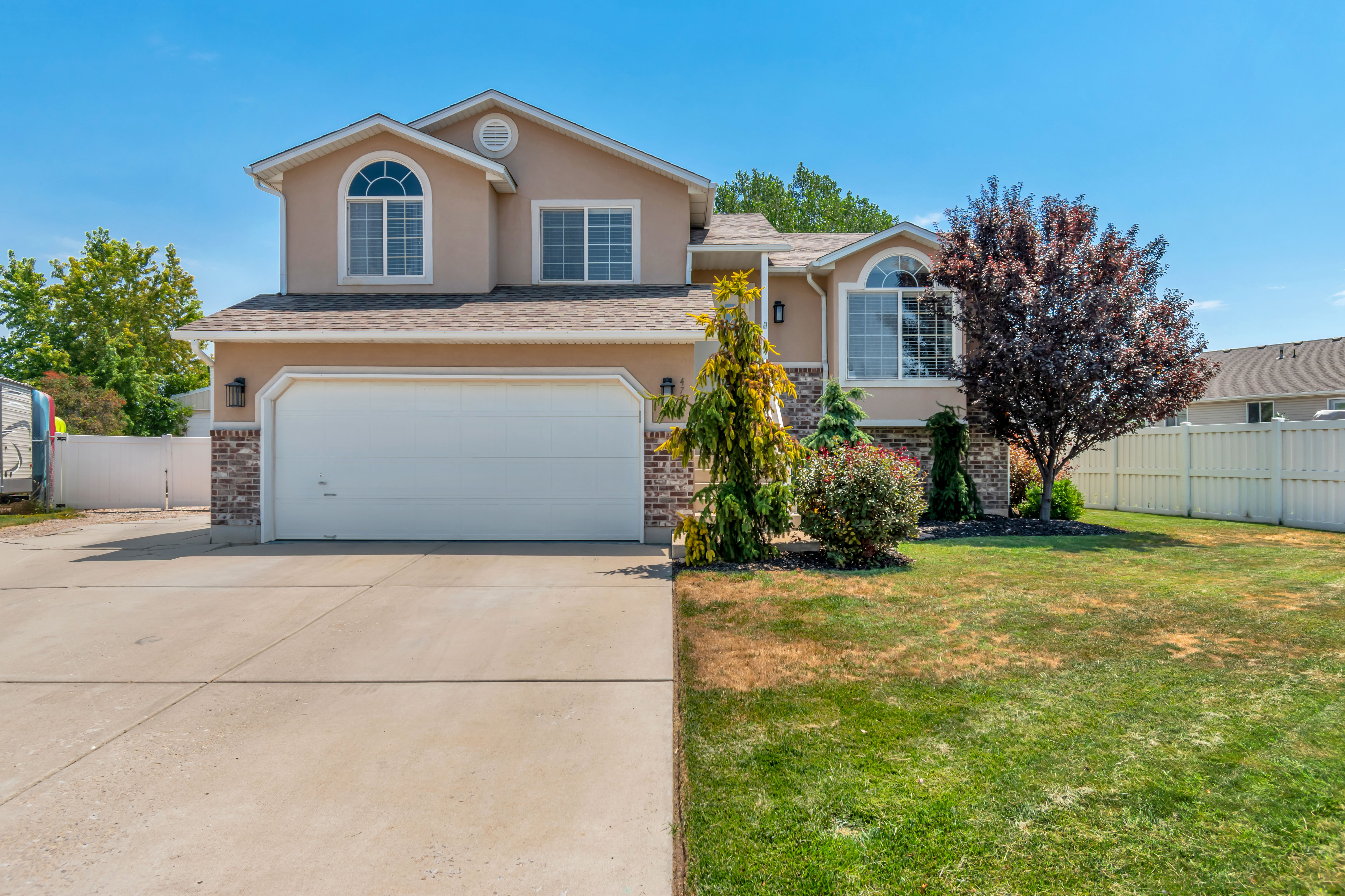 Two-story stucco and brick-veneer exterior with an integrated two-car garage