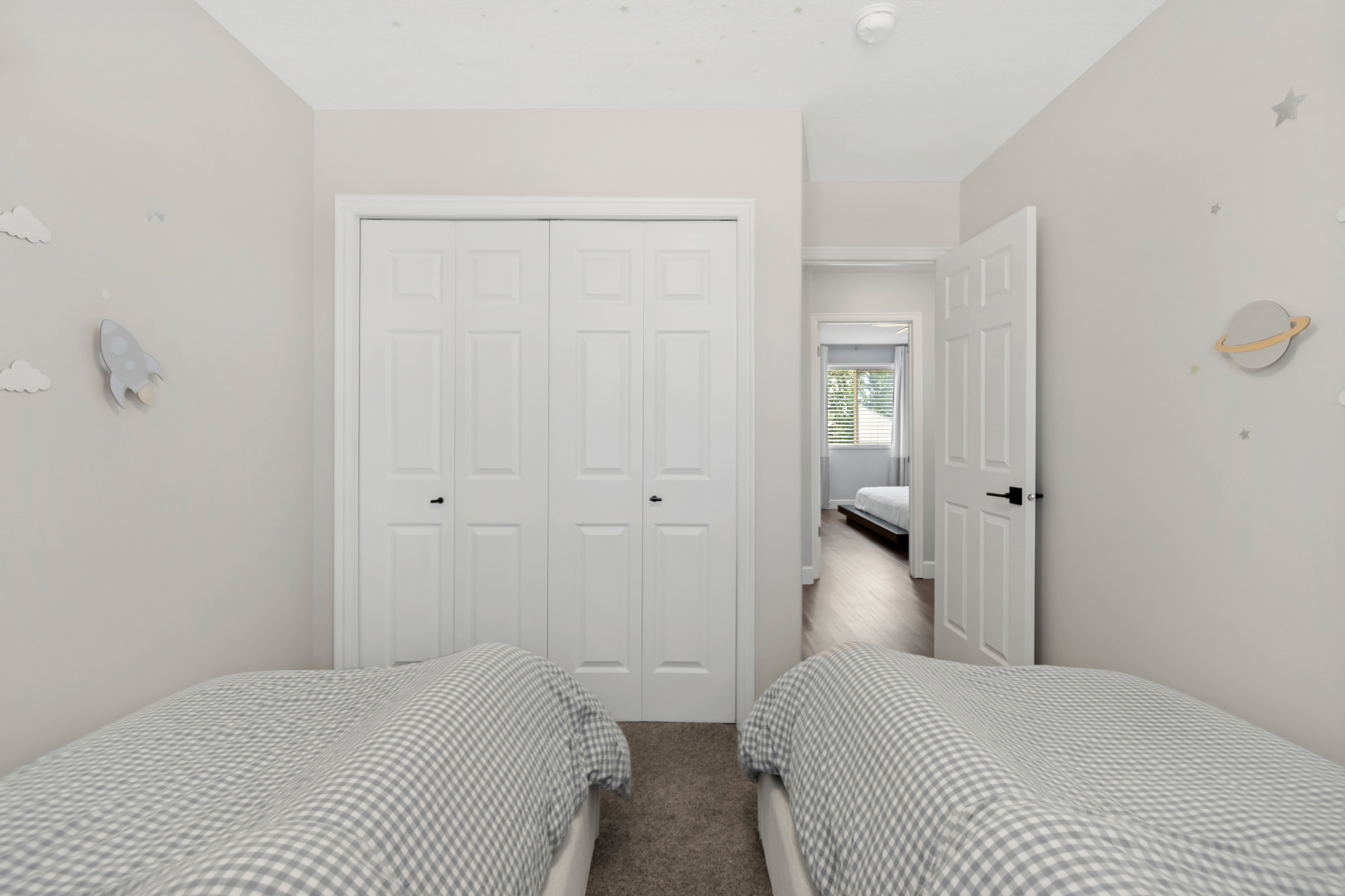 Bedroom featuring light-toned walls, bi-fold closet doors, and carpet flooring