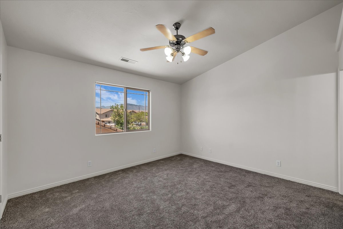 Designed for comfort and relaxation, the spacious primary suite offers abundant natural light, neutral tones, and a ceiling fan.
