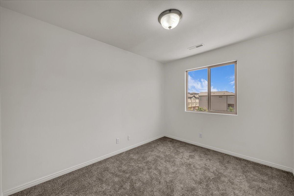 Versatile bedroom with neutral finishes, perfect for guests, a home office, or growing families.