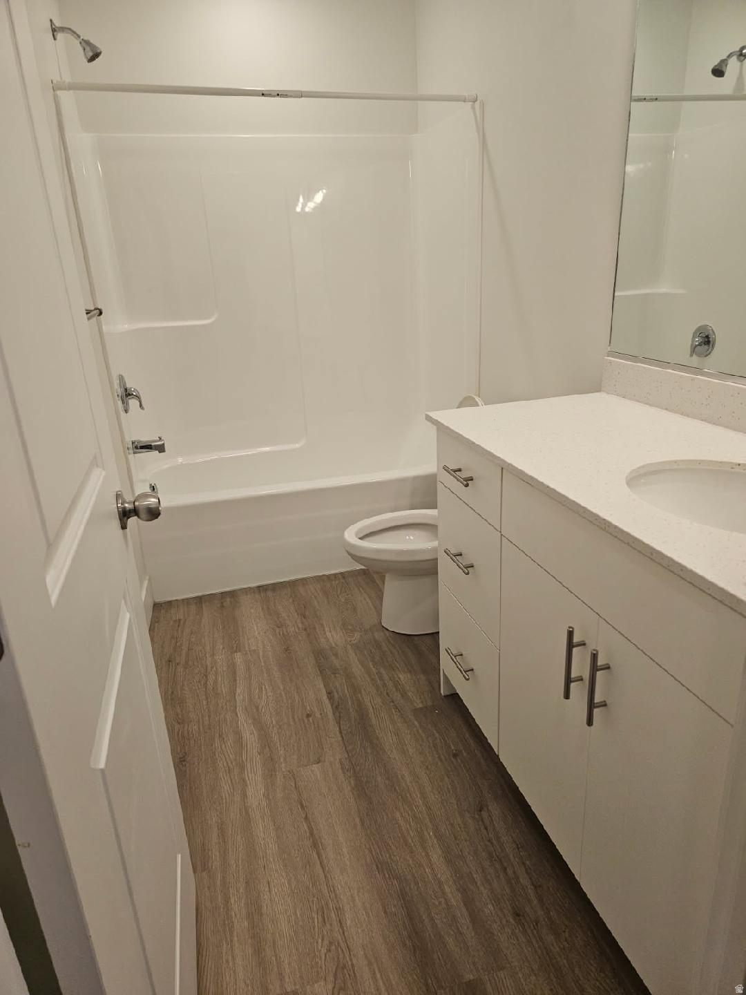 Bathroom featuring a white vanity with a light-toned countertop, a single integrated sink, and brushed nickel hardware