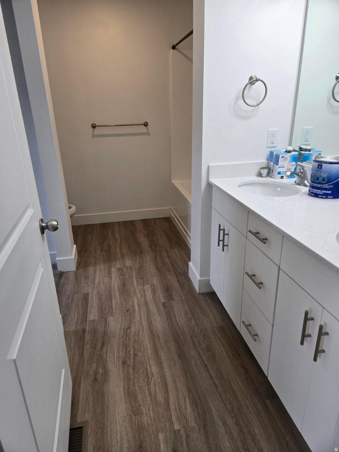 Bathroom featuring a wood-finish floor and white walls