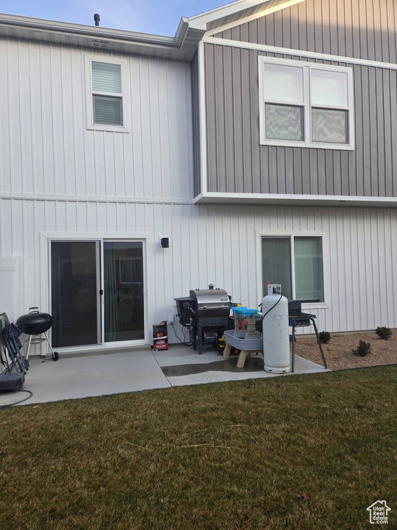 Rear exterior featuring a sliding glass door, multiple windows, and two-tone vertical siding in white and gray