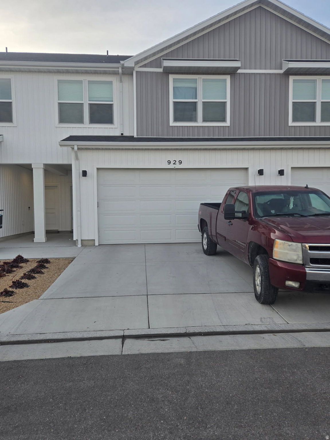 Contemporary townhome exterior featuring dual-tone vertical siding and a prominent two-car garage
