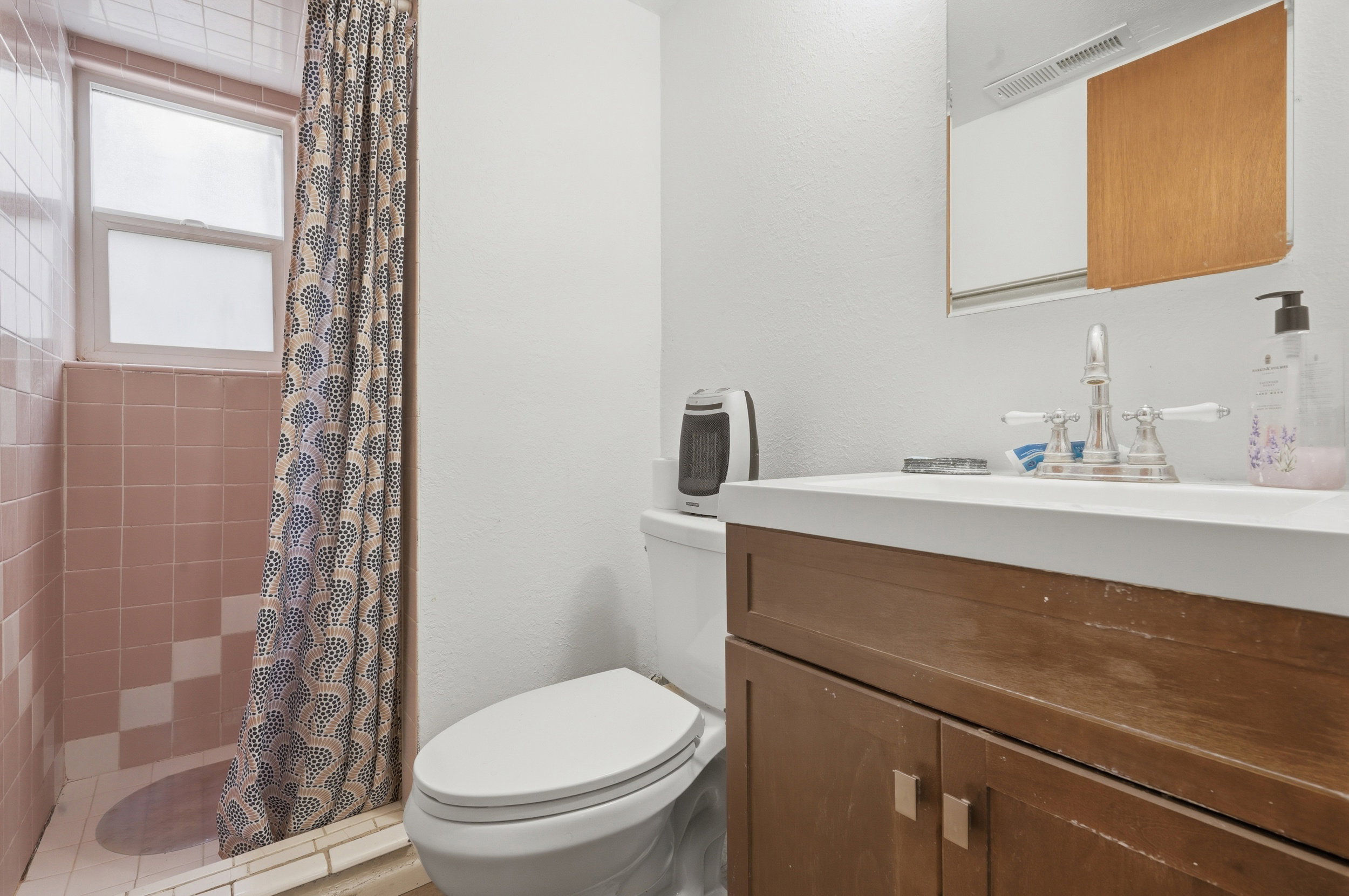 Bathroom featuring a wood-finish vanity with an integrated sink and a two-handle faucet